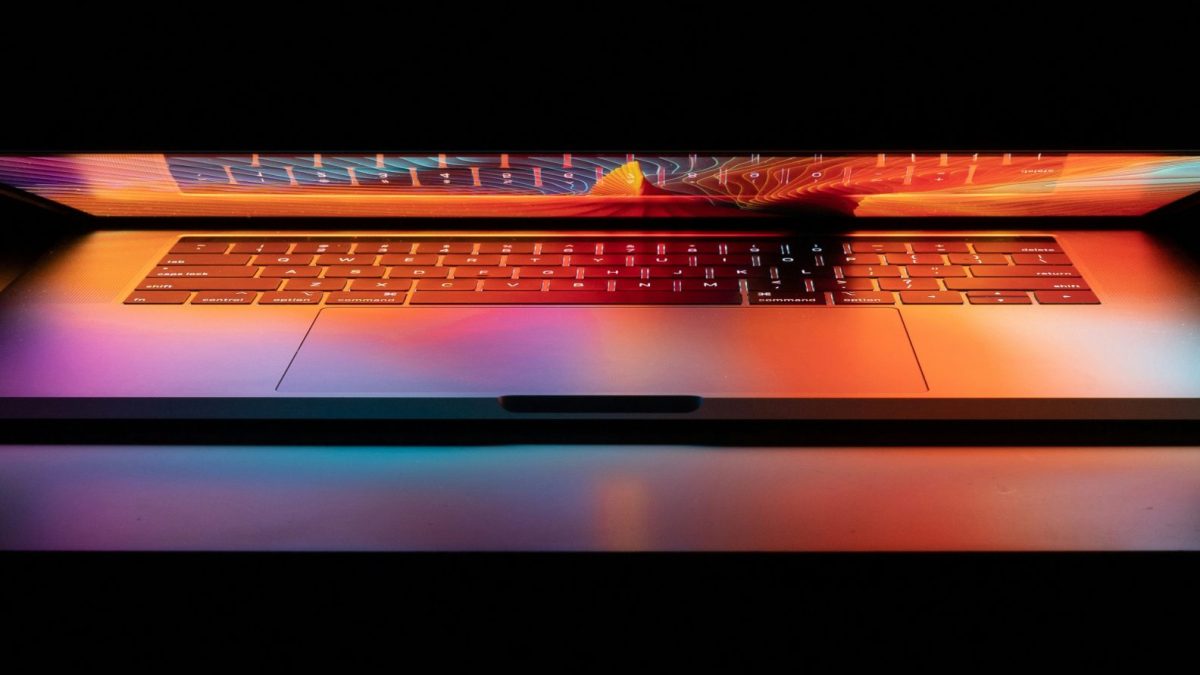 Apple MacBook op donker achtergrond met opgelichte scherm